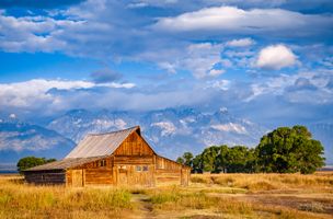 Wooden farmhouse with big mountains in the background in Grand Teton National Park