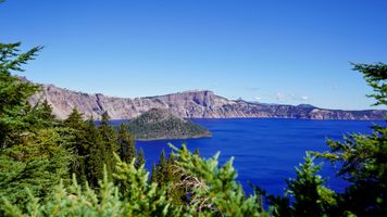 View of the crater lake captured from a vantage point in the forest.